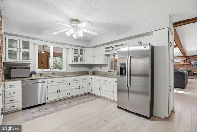 a kitchen with granite countertop a stove sink and cabinets