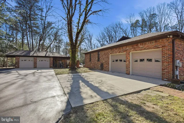 a living room with stainless steel appliances furniture a large window and a wooden floor