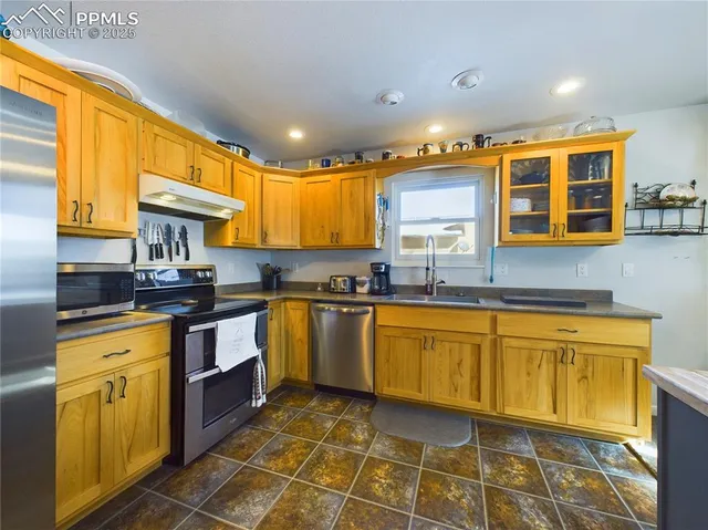 a kitchen with stainless steel appliances granite countertop sink stove and granite counter top