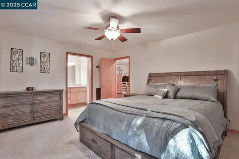 a spacious bedroom with a bed and a chandelier