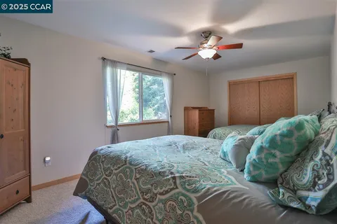 a bedroom with a large bed and a chandelier