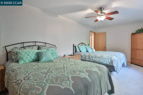 a bedroom with a large bed and a chandelier