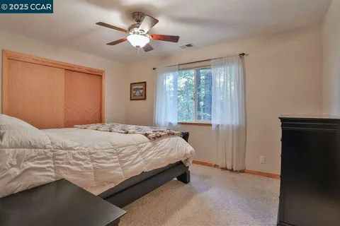 a bedroom with a bed chandelier and a window