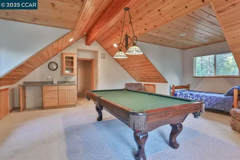 a room with pool table and windows