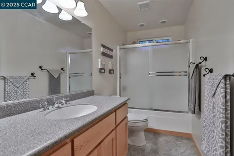 a bathroom with a granite countertop sink toilet and shower