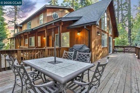 a view of backyard with deck and outdoor seating