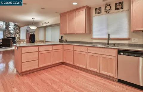 a kitchen with sink cabinets and wooden floor