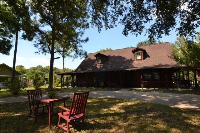 a front view of a house with garden and sitting area