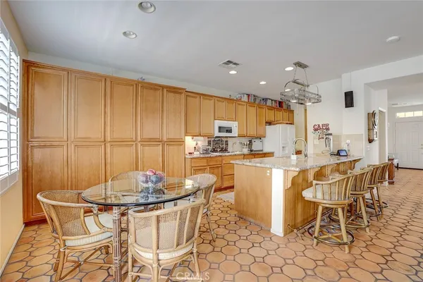 a dining area with stainless steel appliances kitchen island granite countertop a table and chairs