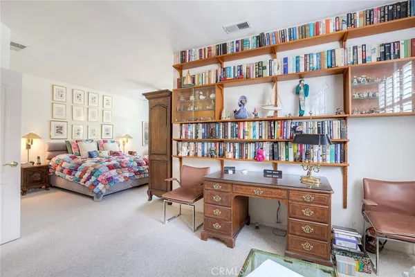 a bedroom with a bed book shelf and a book shelf