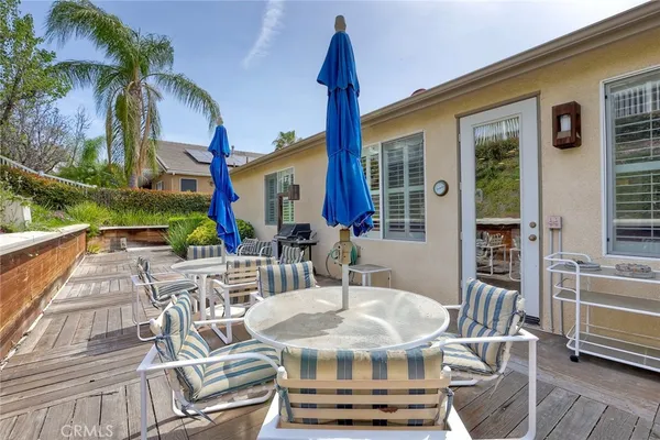 a patio with glass top table and chairs
