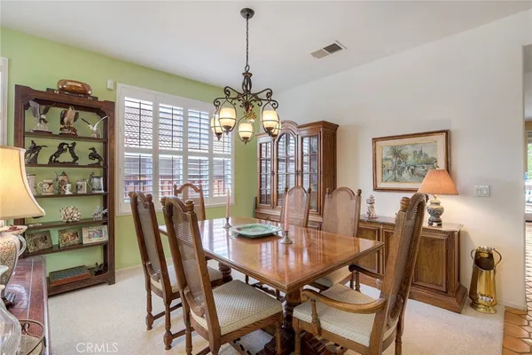 a view of a dining room with furniture and chandelier