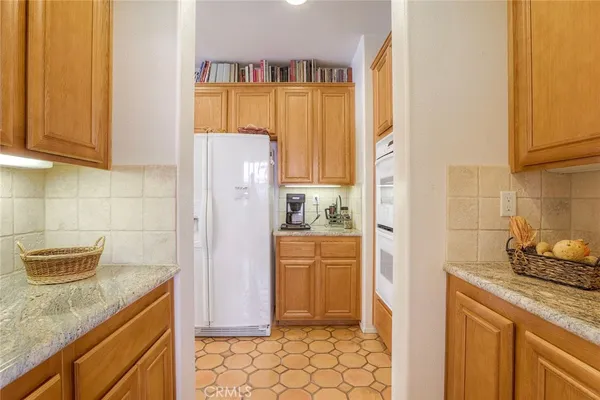 a kitchen with stainless steel appliances granite countertop a refrigerator and a stove