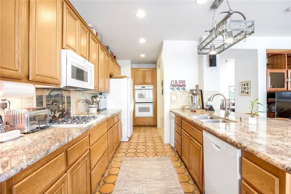 a large kitchen with stainless steel appliances granite countertop a sink and cabinets