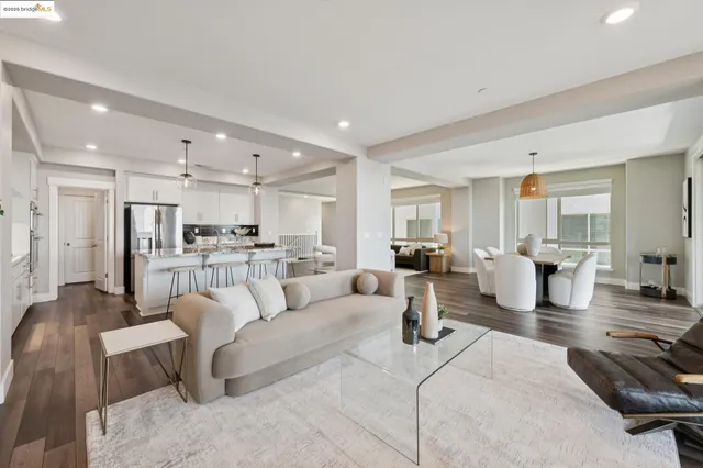 a large kitchen with kitchen island a refrigerator a stove a sink a dining table and chairs