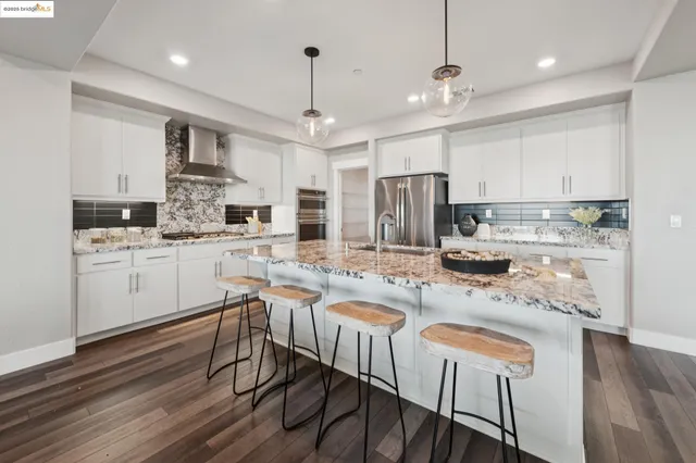 a kitchen with granite countertop stainless steel appliances stove top oven and cabinets