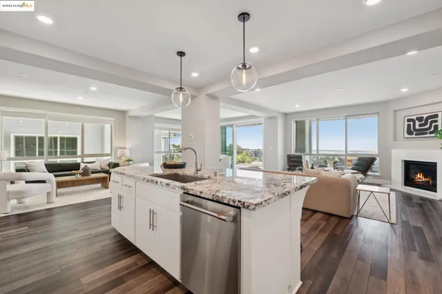 a kitchen with stainless steel appliances granite countertop a sink stove oven and white cabinets
