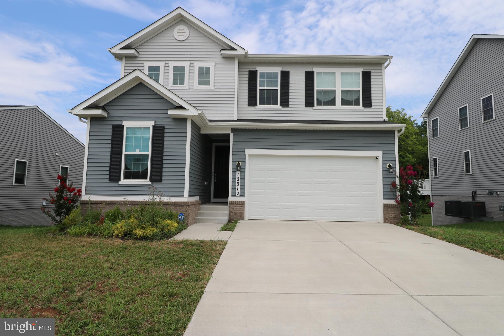 a front view of a house with a garden and plants