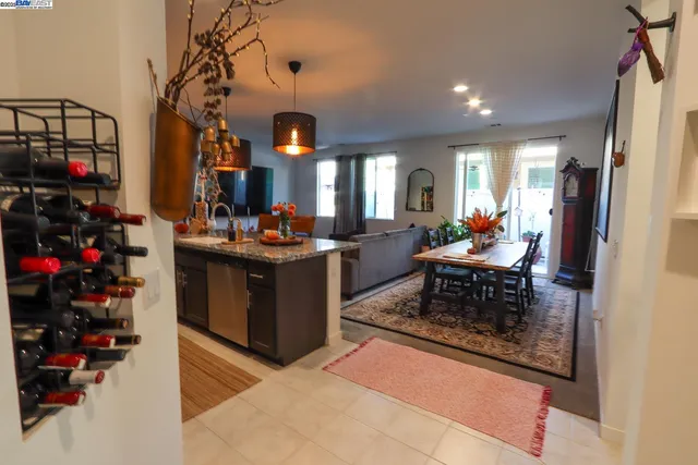 a living room with furniture a dining table and large windows
