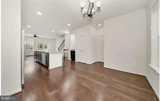 a view of a kitchen with a sink and an empty room