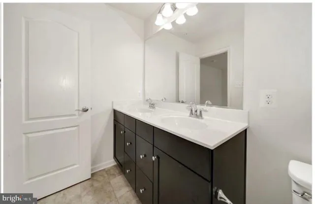 a bathroom with a sink a toilet and a mirror