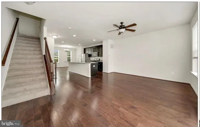 a view of a kitchen with wooden floor and a ceiling fan