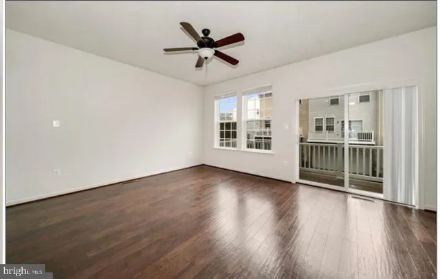 a view of a livingroom with wooden floor and a ceiling fan