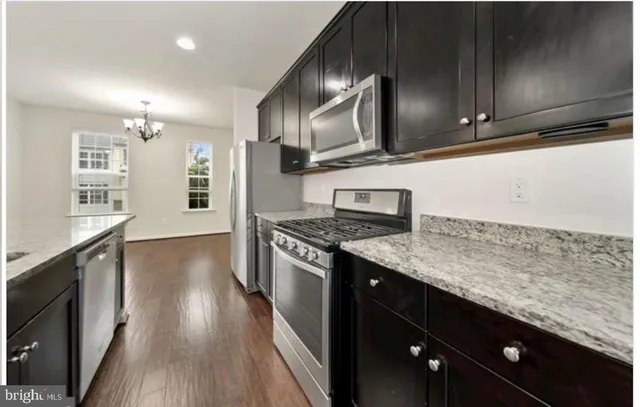 a kitchen with stainless steel appliances granite countertop a sink stove and microwave