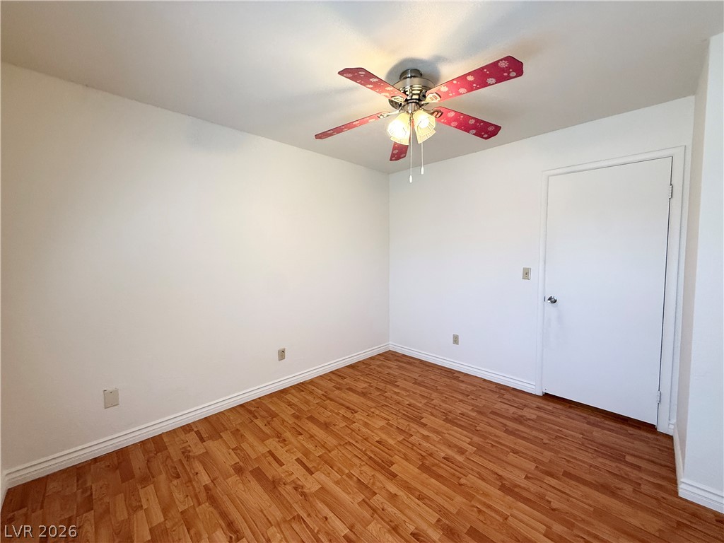 616 Greenway Road Henderson, NV 89002 - Photo 24 of 32 A well-lit bedroom features warm hardwood flooring and a stylish ceiling fan for comfort.