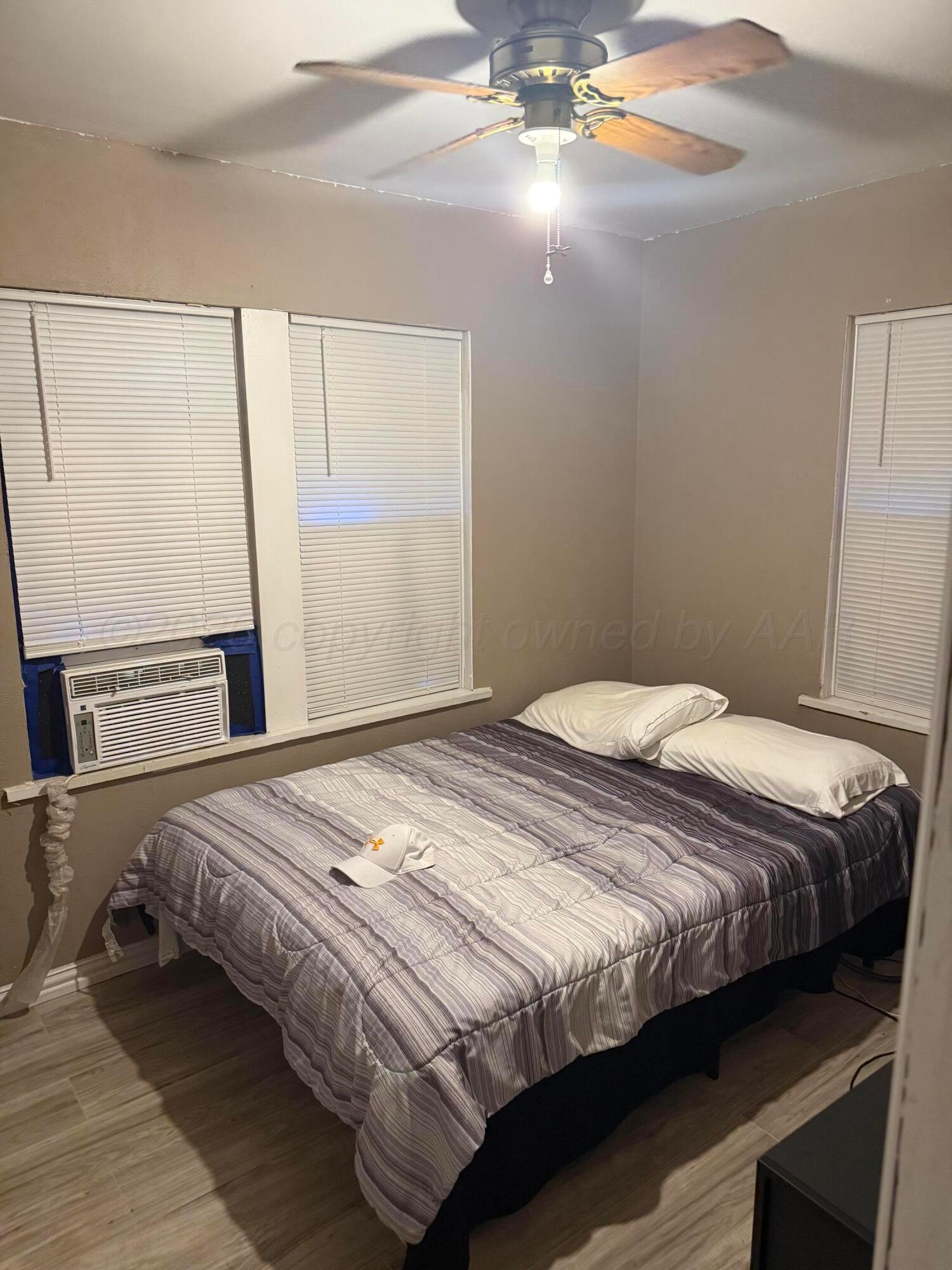 1209 Southwest 10th Avenue Amarillo, TX 79101 - Photo 4 of 6 a bedroom with a bed and a chandelier