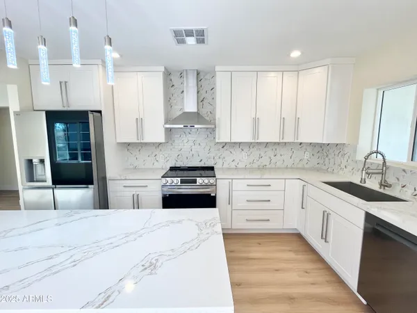 a kitchen with stainless steel appliances kitchen island granite countertop a sink and cabinets