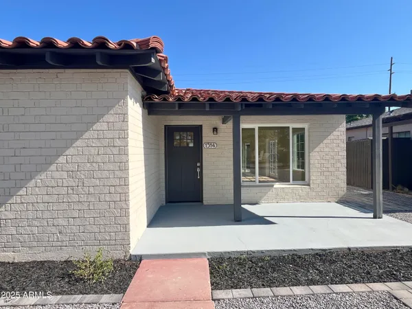 a large kitchen with stainless steel appliances a large counter top a stove a refrigerator cabinets and wooden floor