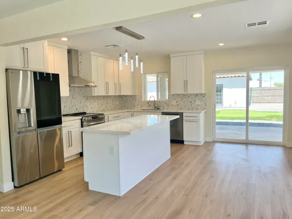 a kitchen with stainless steel appliances granite countertop a stove and a refrigerator