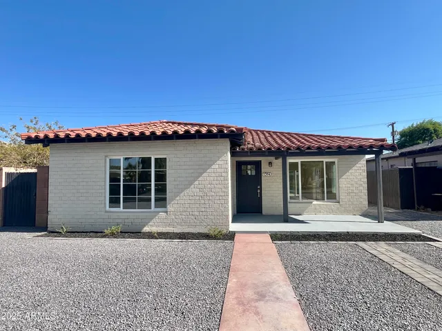 a large kitchen with a center island wooden floor stainless steel appliances and windows
