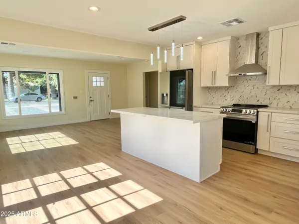 a kitchen with stainless steel appliances granite countertop a stove a sink and a refrigerator