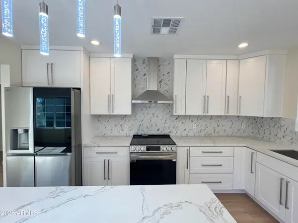 a kitchen with stainless steel appliances granite countertop a stove and a refrigerator