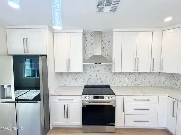 a large kitchen with a large counter top stainless steel appliances and cabinets