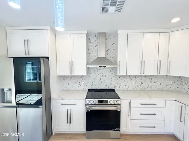 a large kitchen with a large counter top stainless steel appliances and cabinets
