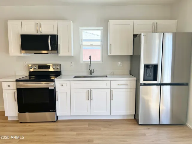 a front view of a house with a yard and trees