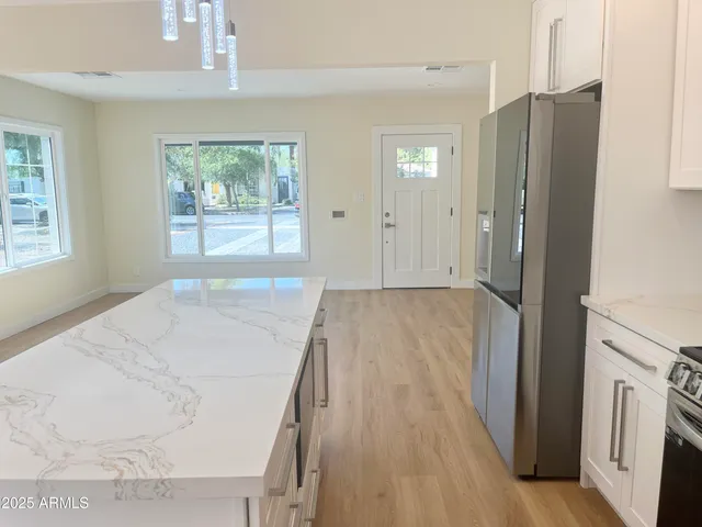 a kitchen with a refrigerator a stove top oven a sink and dishwasher with wooden floor