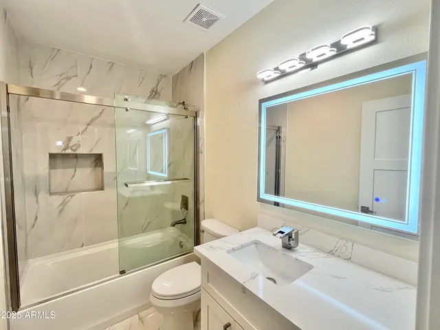 a large kitchen with stainless steel appliances granite countertop a stove top oven a sink dishwasher and white cabinets with wooden floor