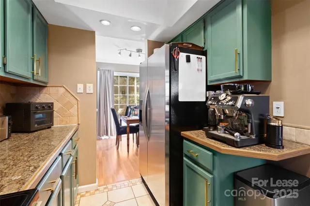 a kitchen with stainless steel appliances granite countertop a refrigerator a stove and a sink