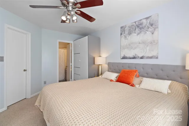 a bedroom with a bed and painting on the wall