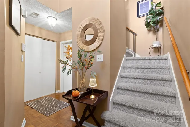 a view of a hallway with wooden floor and a chandelier