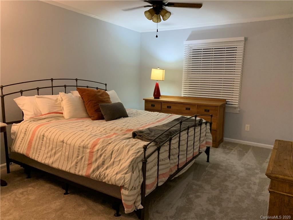 5923 Quail Hollow Road, Unit B Charlotte, NC 28210 - Photo 8 of 15 a bedroom with a bed and a chandelier