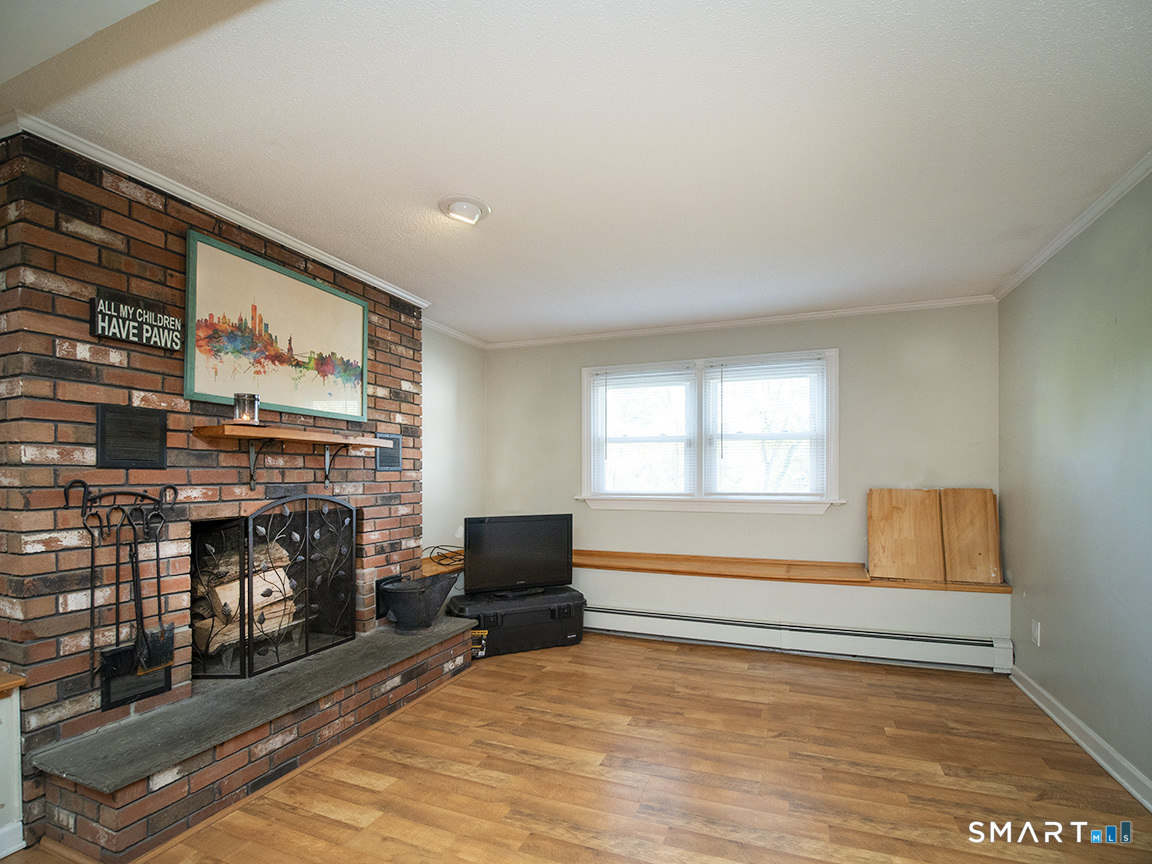 82 Wilcox Road Middletown, CT 06457 - Photo 26 of 27 a living room with furniture a flat screen tv and a fireplace