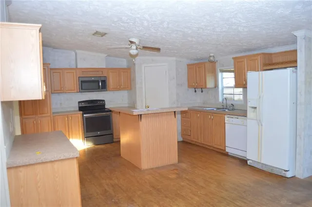 a view of an empty room with a fireplace and a window