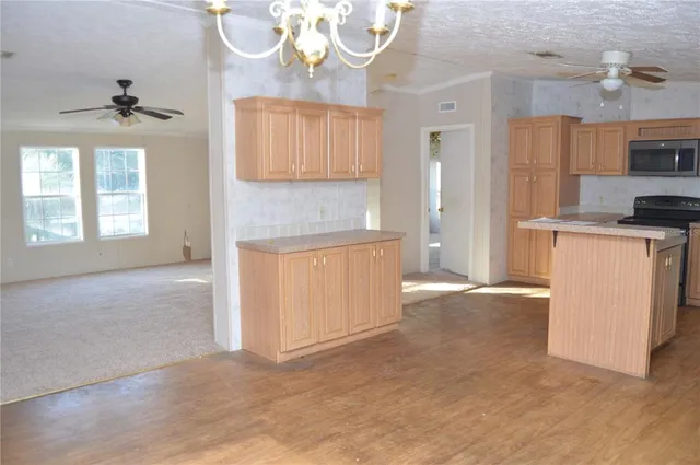 a view of an empty room with a fireplace and a window