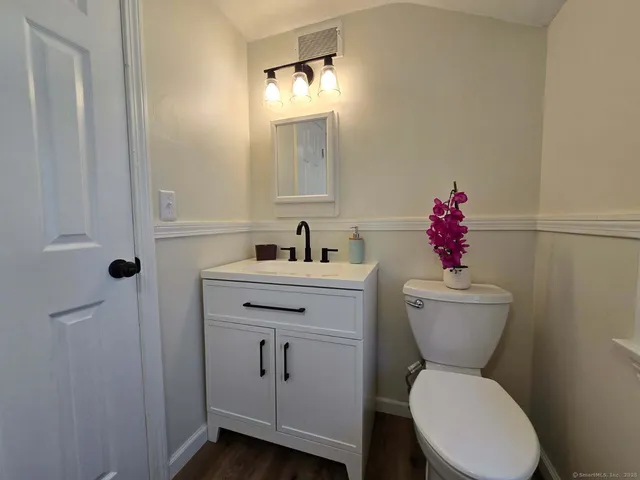 a bathroom with a toilet sink and mirror