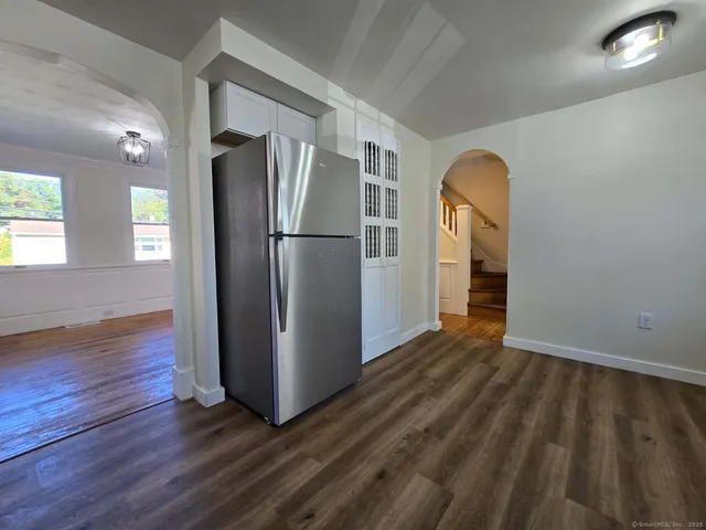 a view of a kitchen with wooden floor and a refrigerator